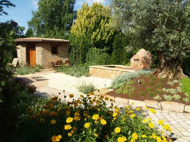 Gartengestaltung mit Gartenhaus aus Naturstein