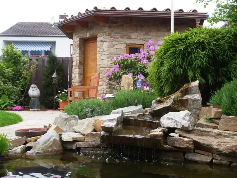 Wasseranlage mit Felsen in einem Garten von LA CAVA